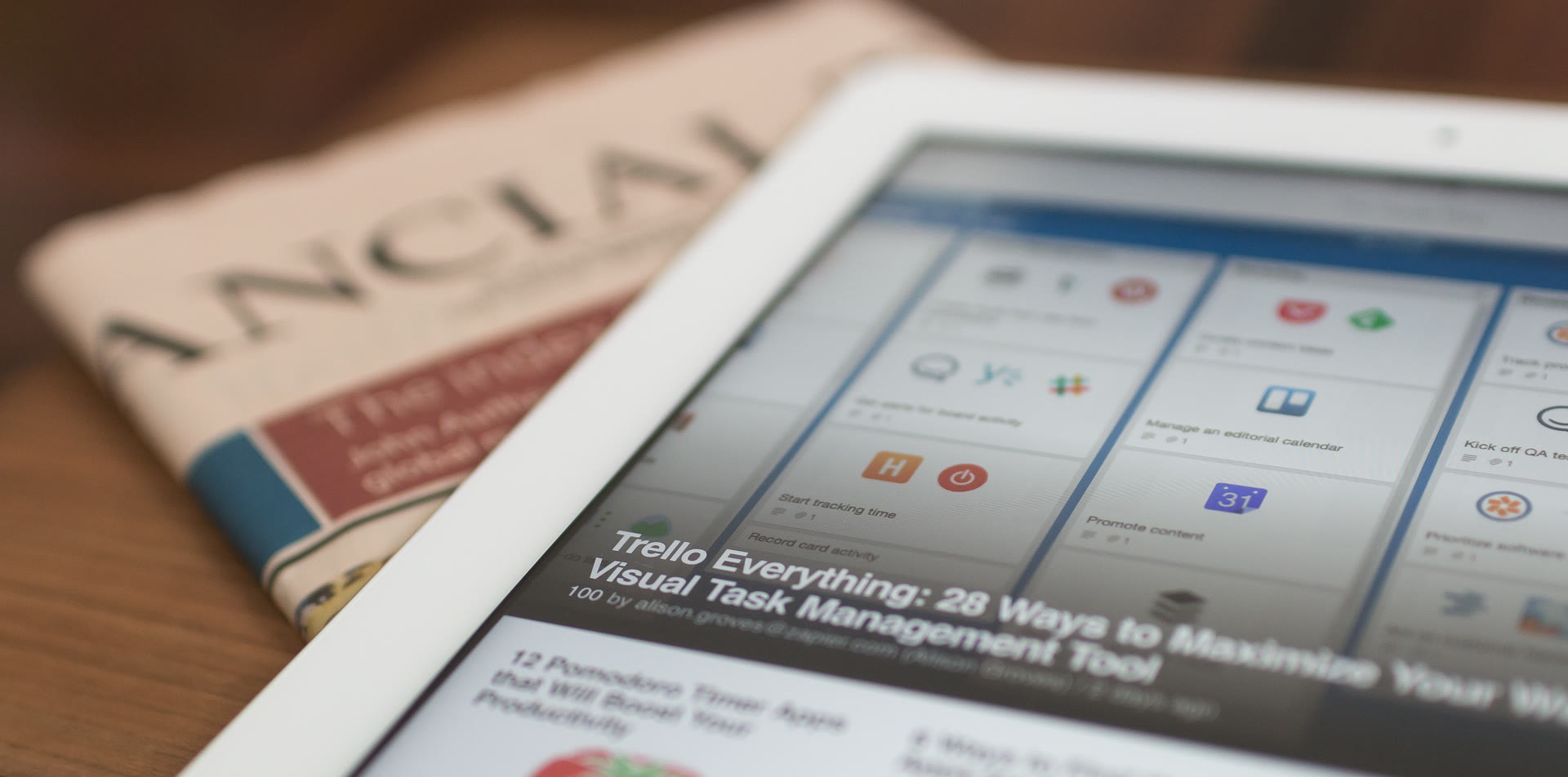 Tablet displaying digital news resting on a newspaper